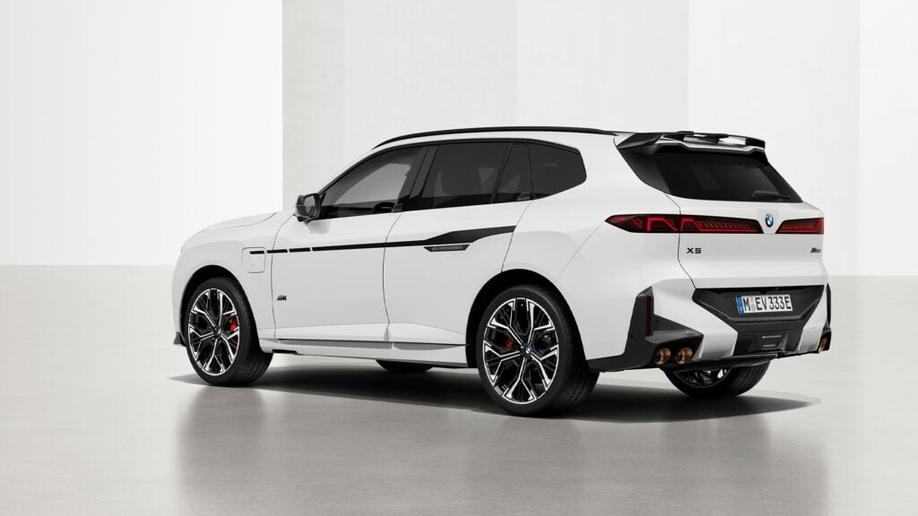 Vit BMW X5 snett bakifrån i studio.