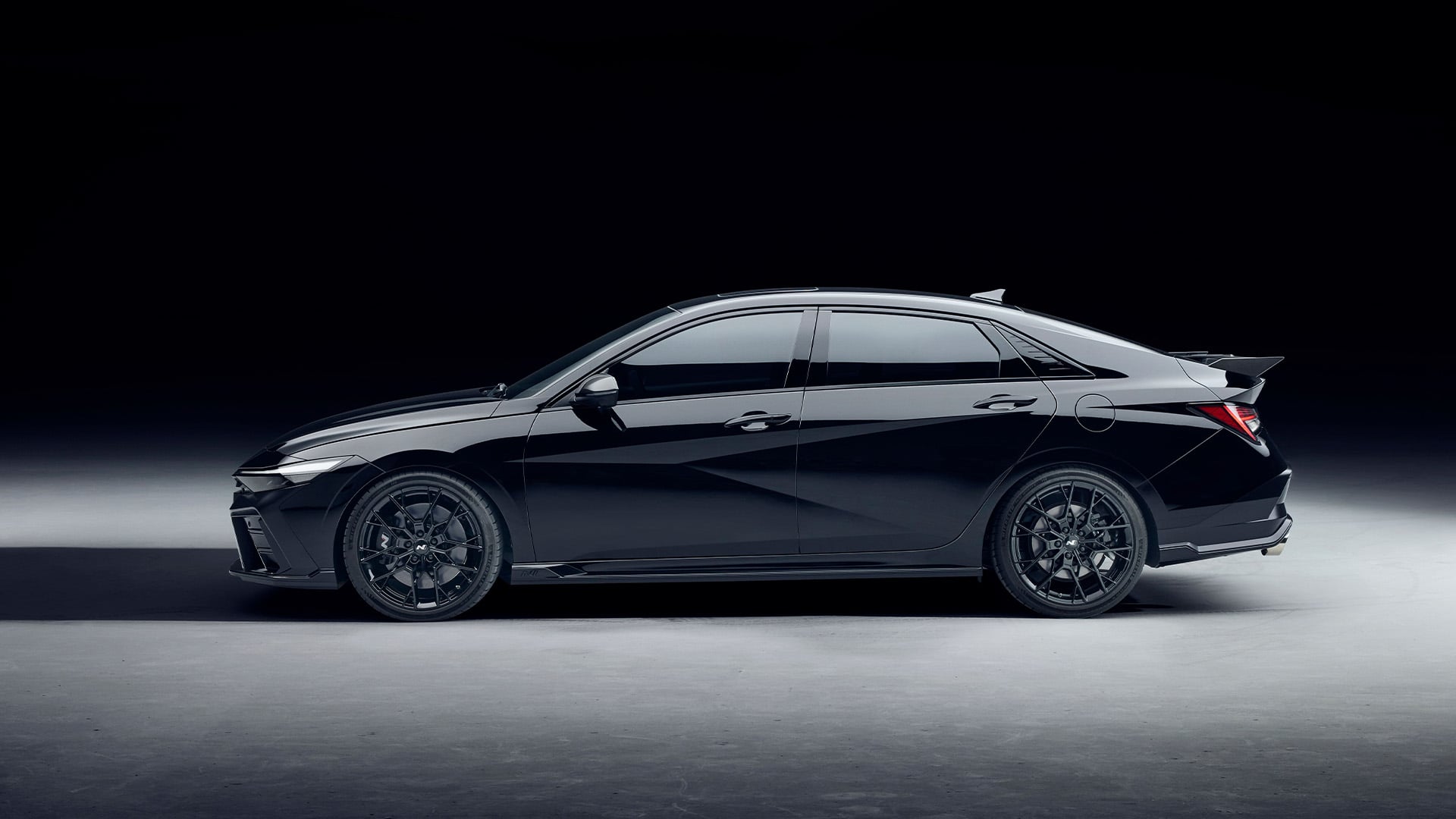 Svart Hyundai Elantra N Monochrome i profil i studiomiljö.