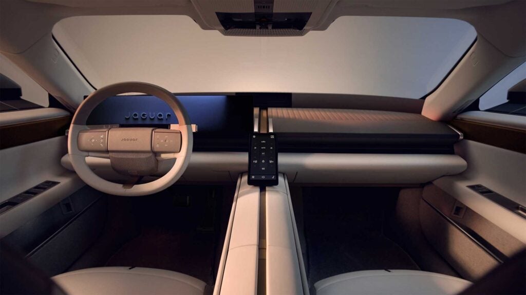Interiören i Jaguar Type 01 med avskalad instrumentpanel, digital förardisplay och stående pekskärm på mittkonsolen.