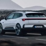 Vit Polestar 4 fotograferad bakifrån under körning på väg i bergslandskap.