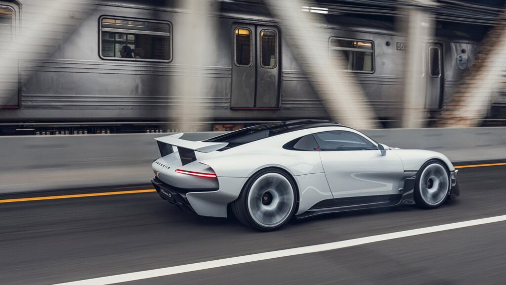 Porsche Mission S i profil med tunnelbanetåg i bakgrunden.