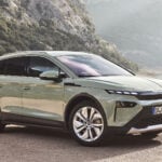 Ljusgrön Skoda Elroq snett från sidan med havet i bakgrunden.