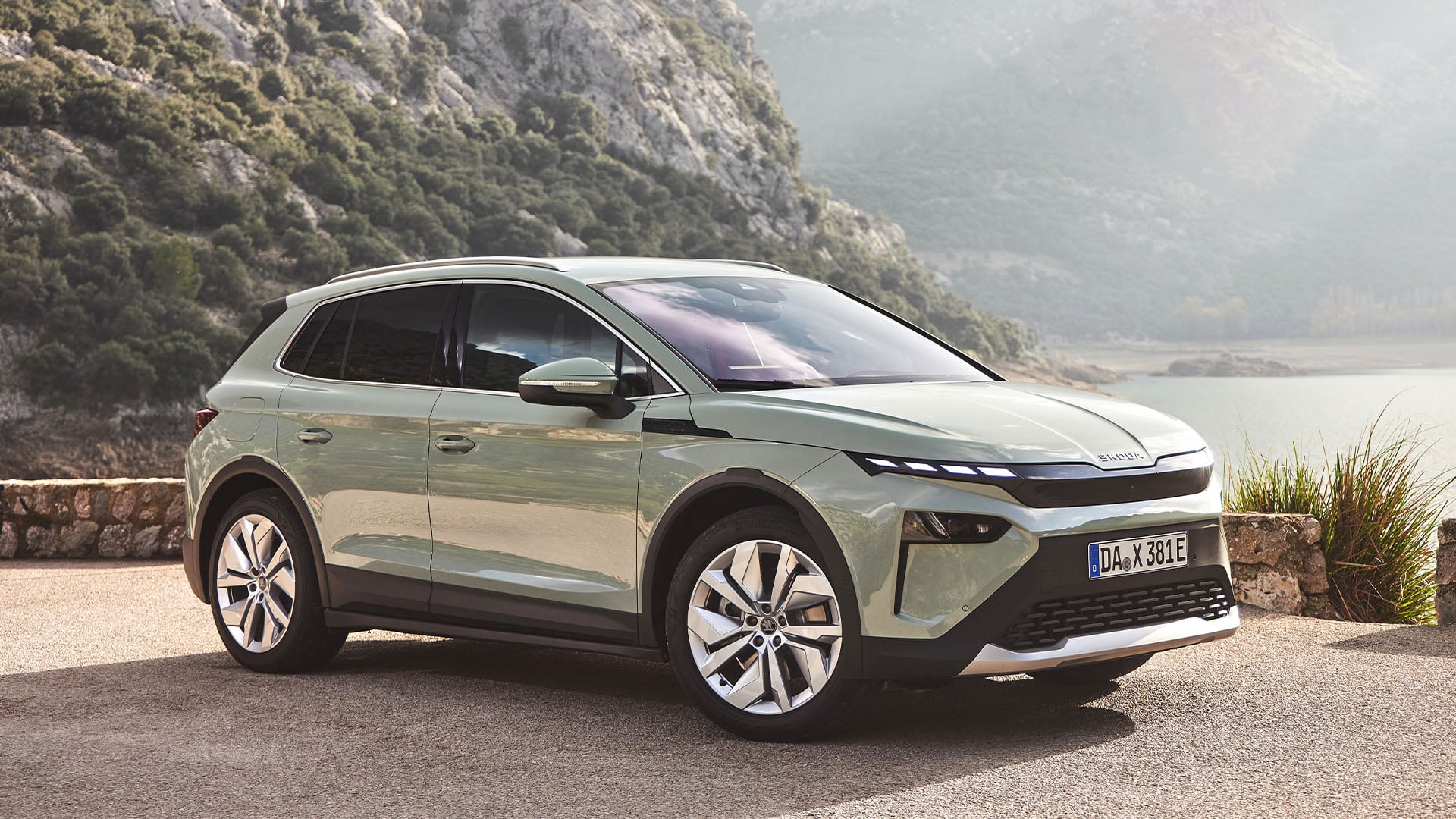 Ljusgrön Skoda Elroq snett från sidan med havet i bakgrunden.